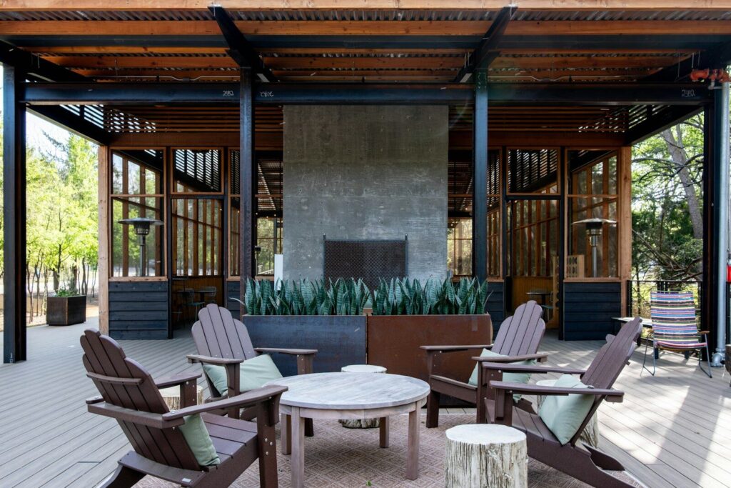 An outdoor patio with a fireplace and adirondack chairs